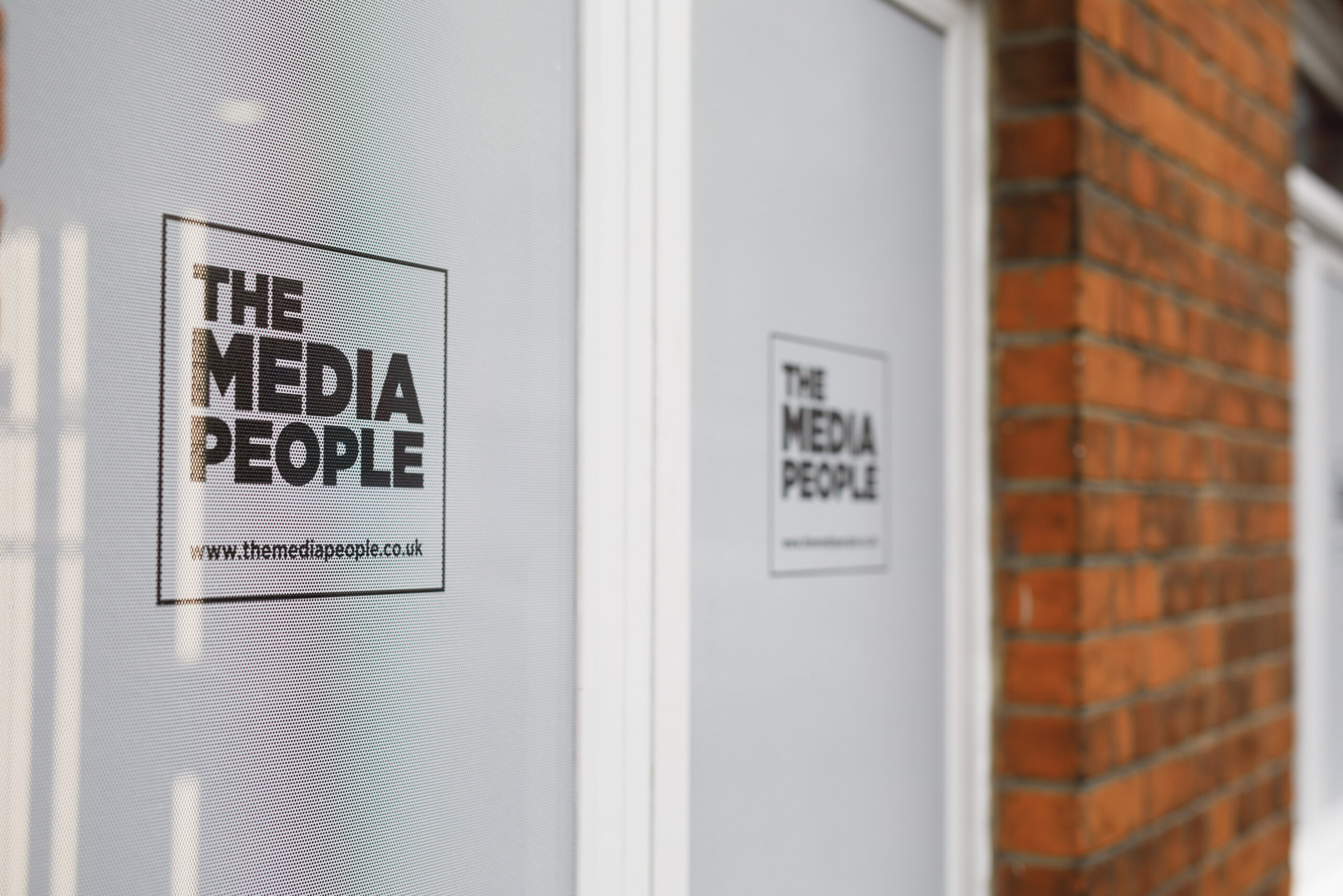 The Media People logo and www.themediapeople.co.uk on a frosted office window