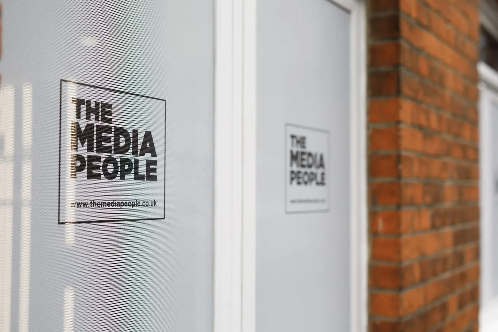 The Media People logo and www.themediapeople.co.uk on a frosted office window