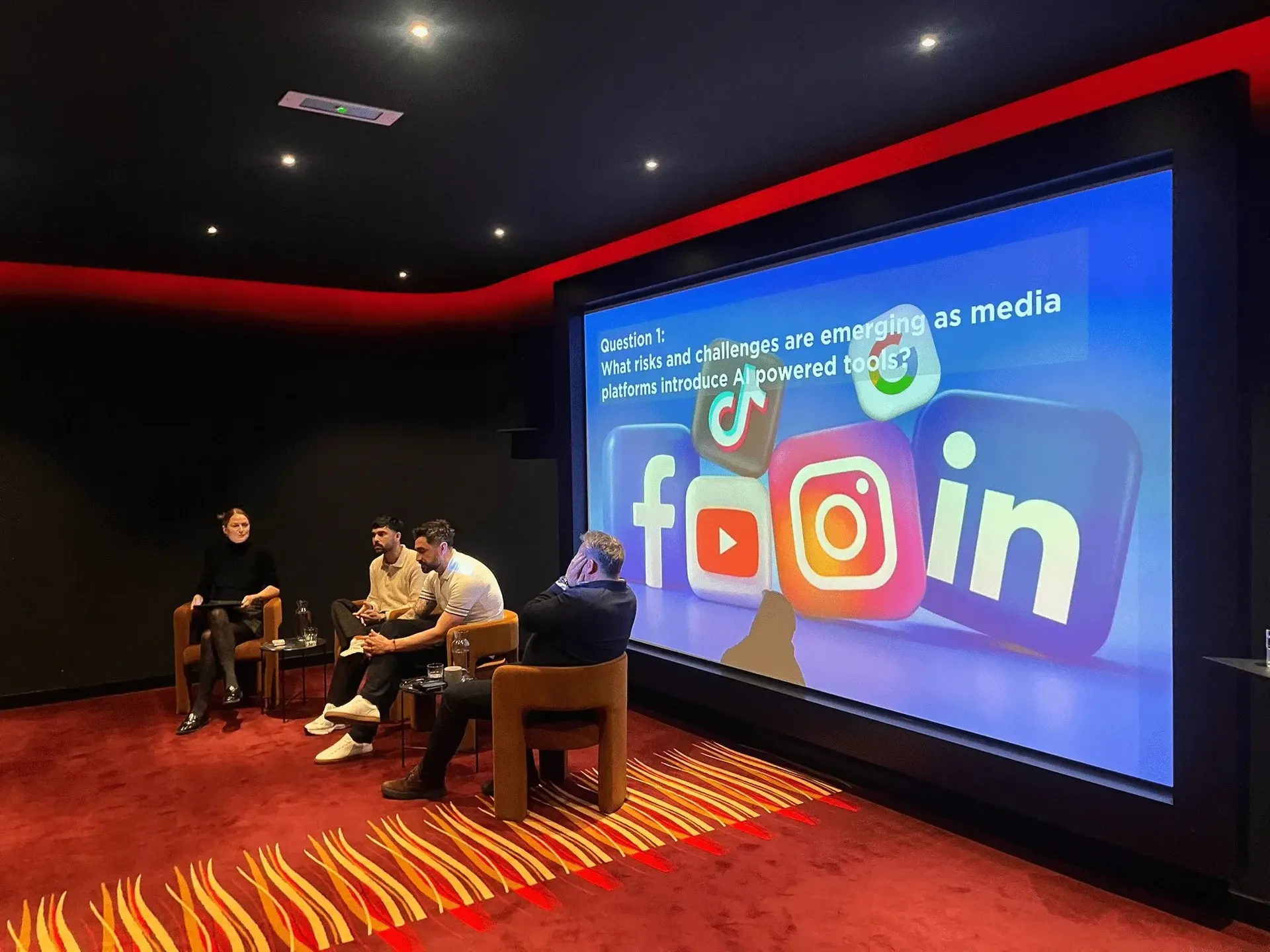 Panel discussion on the risks of AI-powered tools on media platforms, with social media logos on screen